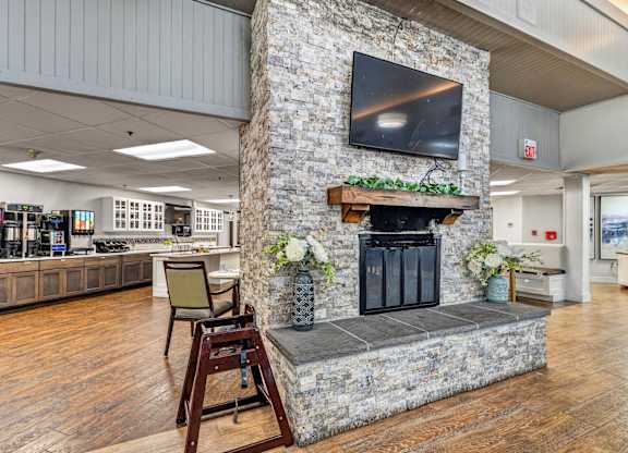 A stone fireplace with a flat screen TV above it.