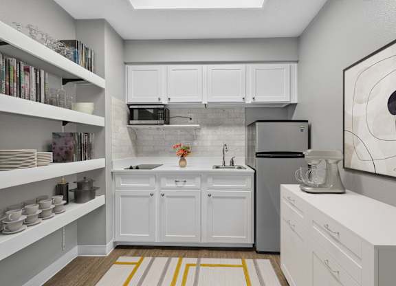 A kitchen with white cabinets and a grey backsplash.