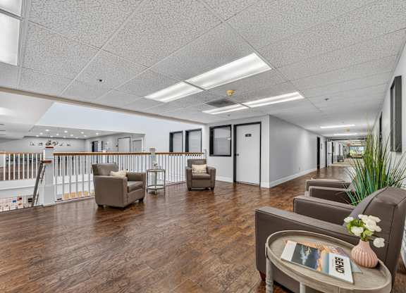 A spacious living room with a wooden floor and furniture.