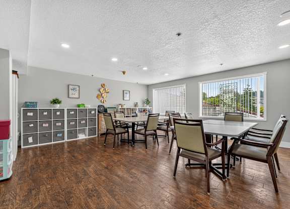 A room with a table and chairs and a cabinet with drawers. Craft and activity room.