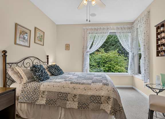 A bedroom with a bed, a chair, and a window with curtains.