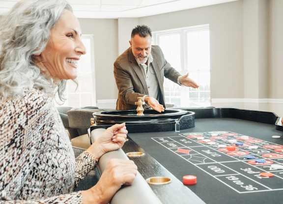 A man is teaching a woman how to play a game on a black table.