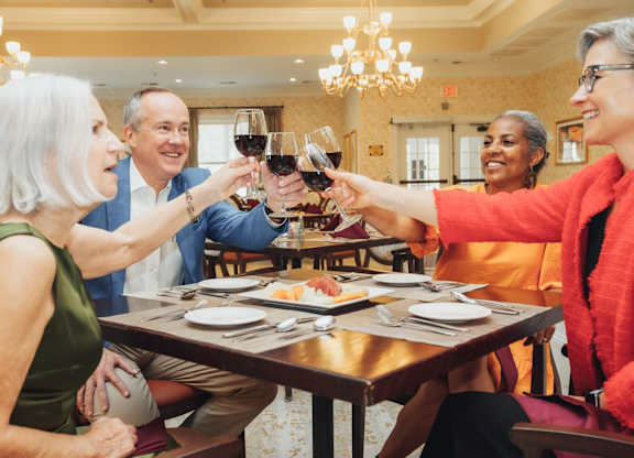 A group of people toasting with wine glasses at a table.
