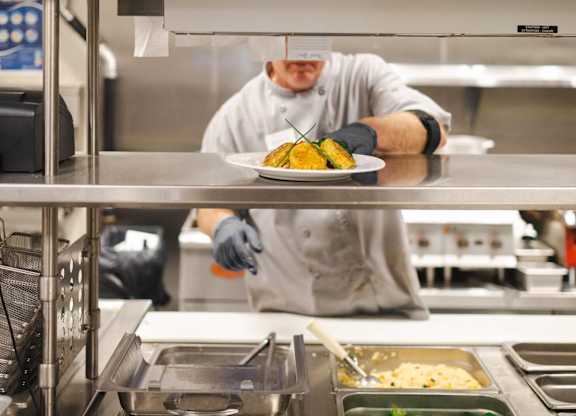 A chef is preparing food in a professional kitchen.