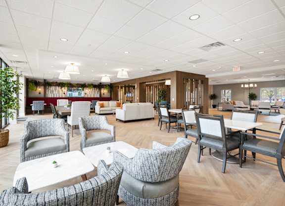 A large room with a lot of grey chairs and tables.