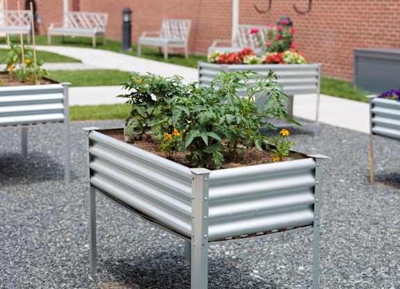 A metal bench with a planter on top of it.
