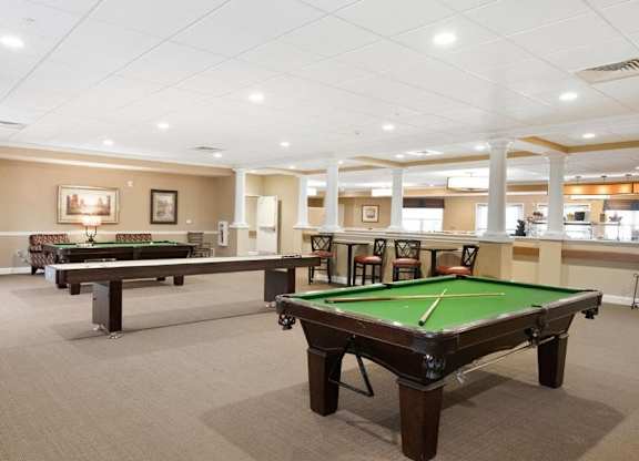 A room with a pool table and a billiard table.