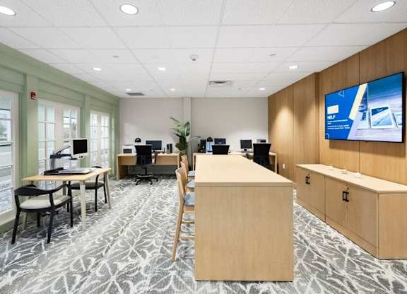 A modern office space with a large screen TV mounted on the wall.