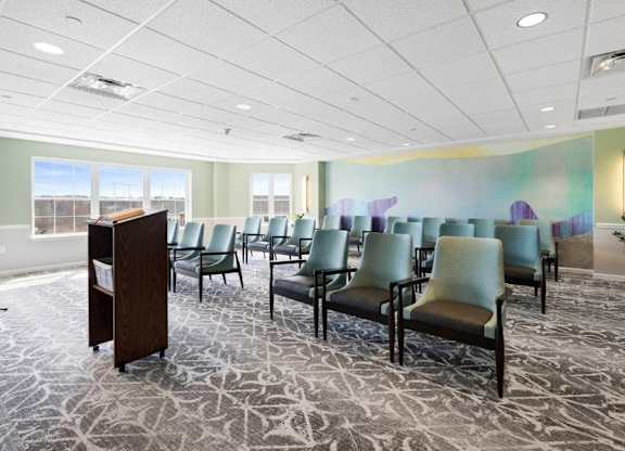 A room with a podium, chairs, and a patterned carpet.
