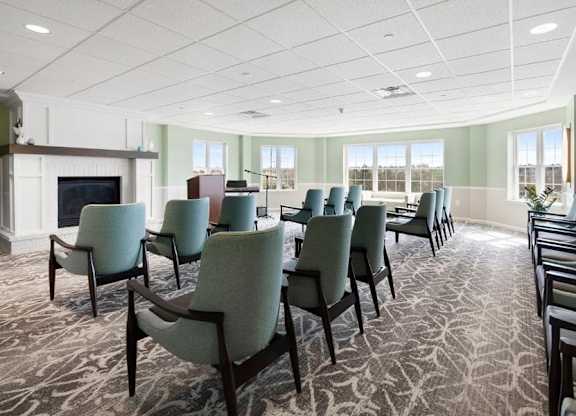 A conference room with a fireplace and chairs.