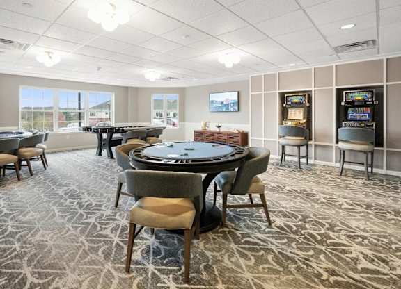 A room with a poker table and chairs.