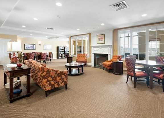 A living room with a fireplace and a dining table.