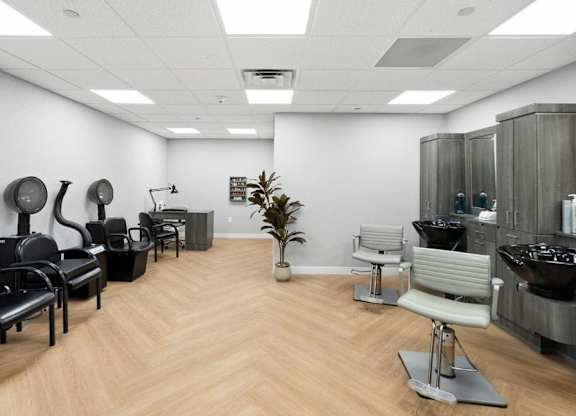 A room with black and white chairs and a wooden floor.