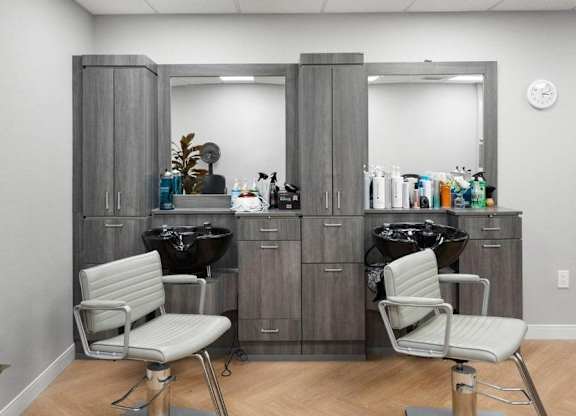 A salon with two chairs and a vanity table.