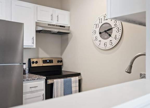 A kitchen with a clock on the wall.