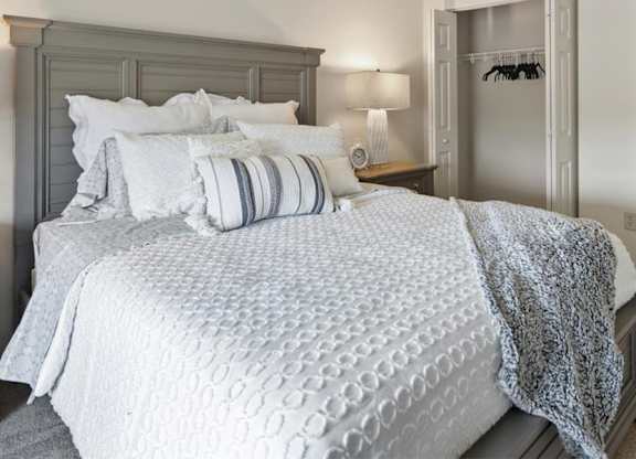 A bed with a white comforter and pillows is in the image.