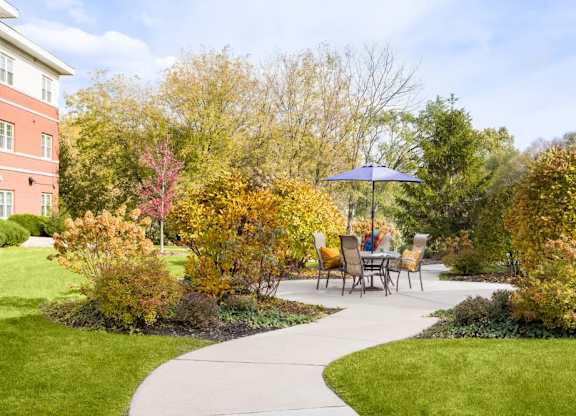 A garden with a table and chairs under an umbrella.
