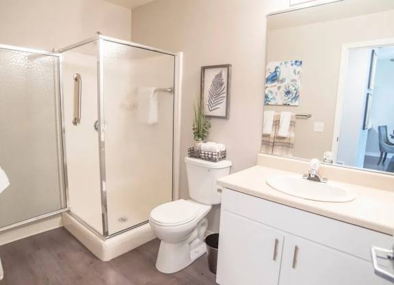 A bathroom with a toilet, sink, and shower.