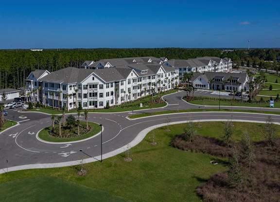 A large, well-maintained resort with multiple buildings and a roundabout in the foreground. at Atwater at Nocatee Apartments, Florida, 32081
