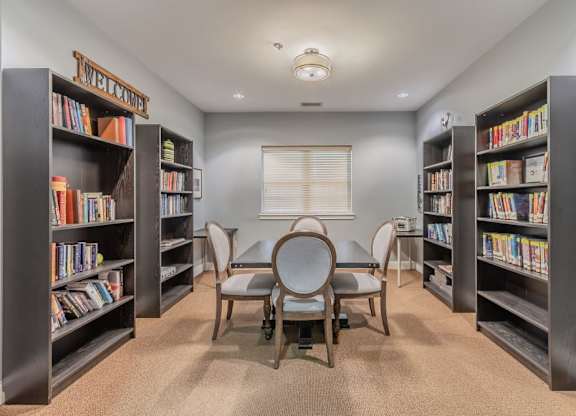 Community library with reading table and bookshelves at Schuyler Commons Apartments, Utica, New York