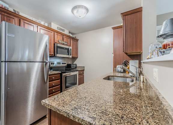Kitchen with granite counters and stainless steel appliances at Schuyler Commons Apartments, New York