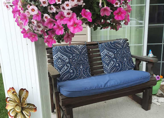 Outdoor seating bench with floral decor at Schuyler Commons Apartments, New York