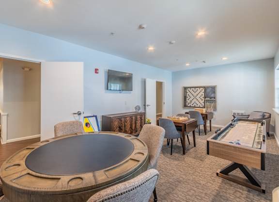 Game room with poker table and shuffleboard at Glenmont Abbey Village, 55+ Apartments, New Jersey, 12077