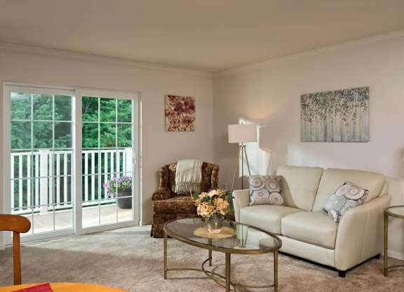 Furnished living room with patio access at Glenmont Abbey Village, 55+ Apartments, Glenmont, NJ 12077