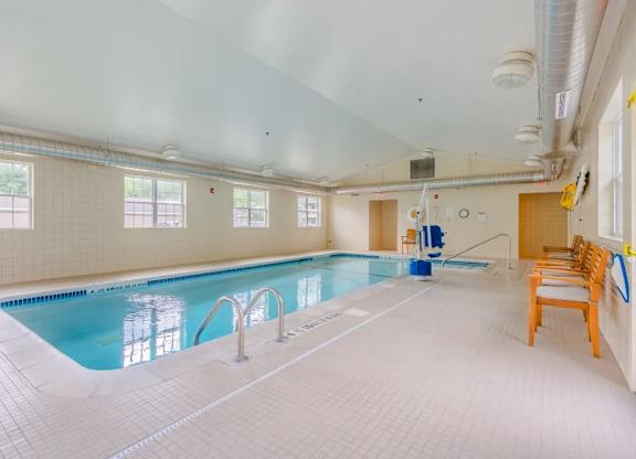 Indoor swimming pool with seating area at Glenmont Abbey Village, 55+ Apartments, Glenmont, NJ 12077