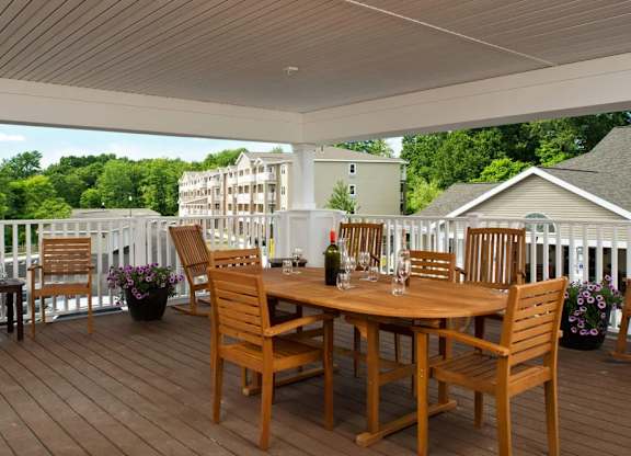 Covered deck with dining table and chairs at Glenmont Abbey Village, 55+ Apartments, Glenmont, New Jersey