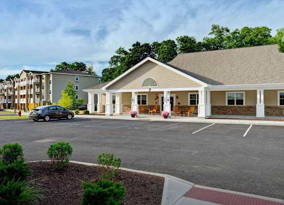 Clubhouse entrance with covered porch and parking at Glenmont Abbey Village, 55+ Apartments, Glenmont