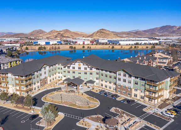 Aerial view of modern apartment complex with lake at Mountain Lakes Estates Apartments, Reno, NV