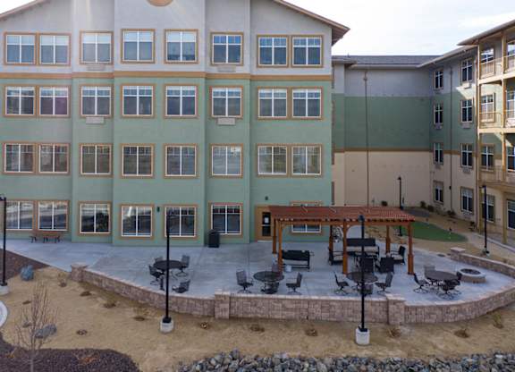 Four story apartment building with outdoor patio area at Mountain Lakes Estates Apartments, Reno