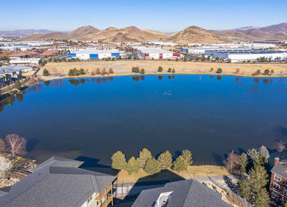 Aerial view of lakefront community with industrial buildings at Mountain Lakes Estates Apartments, Reno, NV 89521