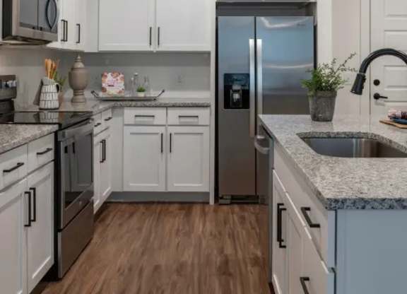 A kitchen with white cabinets and a stainless steel refrigerator. at Atwater at Nocatee Apartments, Toledo, Florida