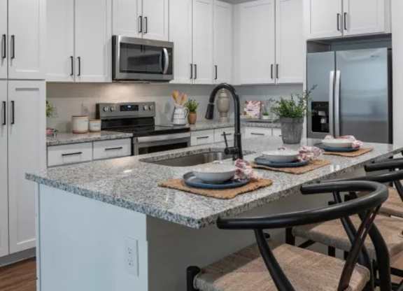 A kitchen with granite countertops and white cabinets. at Atwater at Nocatee Apartments, Toledo, FL
