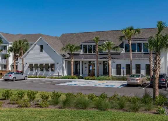 A white building with a grey roof and a car parked in front. at Atwater at Nocatee Apartments, Toledo