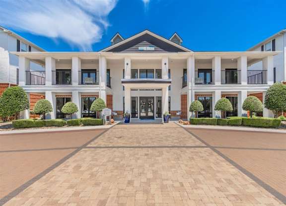 A large, modern building with a central entrance and a symmetrical facade. at The Spring at Silverton Apartments, Texas