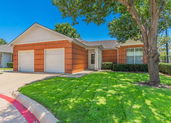 A house with a red brick exterior and a white garage door. at The Spring at Silverton Apartments, Fort Worth