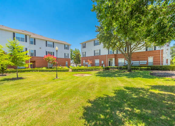 A grassy area in front of apartment buildings. at The Spring at Silverton Apartments, Fort Worth, Texas