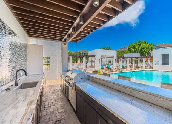 A kitchen with a pool in the background. at The Spring at Silverton Apartments, Fort Worth, TX