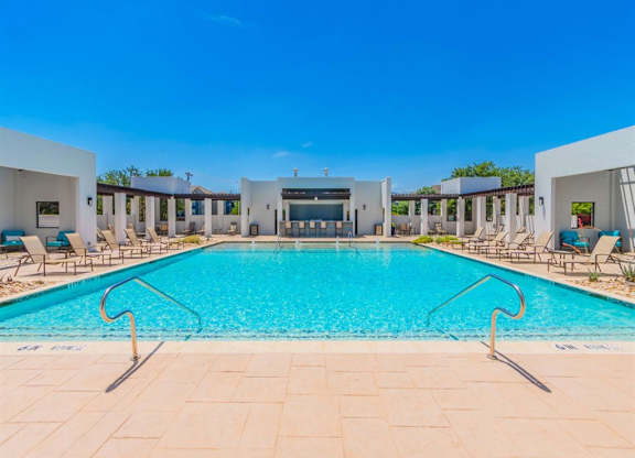 A large swimming pool with a clear blue sky above. at The Spring at Silverton Apartments, Fort Worth, TX