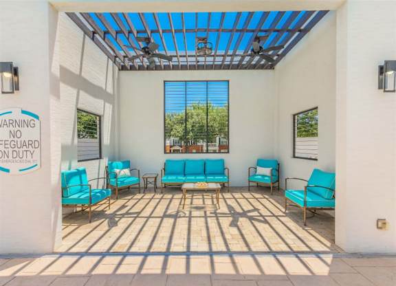 A sunny day at the patio with blue chairs and a warning sign. at The Spring at Silverton Apartments, Texas, 76133