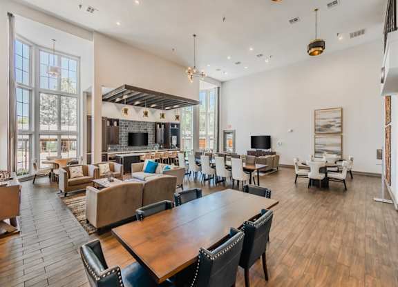 A spacious living room with a fireplace and a dining table. at The Spring at Silverton Apartments, Fort Worth, Texas