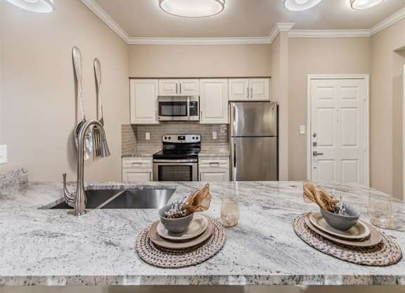 A kitchen with a marble countertop and stainless steel appliances. at The Spring at Silverton Apartments, Fort Worth, TX, 76133