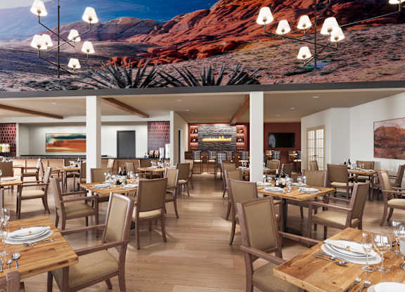 A restaurant with tables and chairs and a desert scene on the wall. DAS design and renderings.