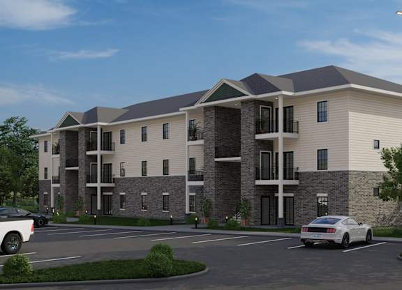 A modern apartment building with a parking lot in front.