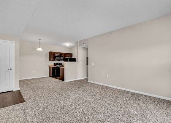 A room with a carpeted floor and a white door.