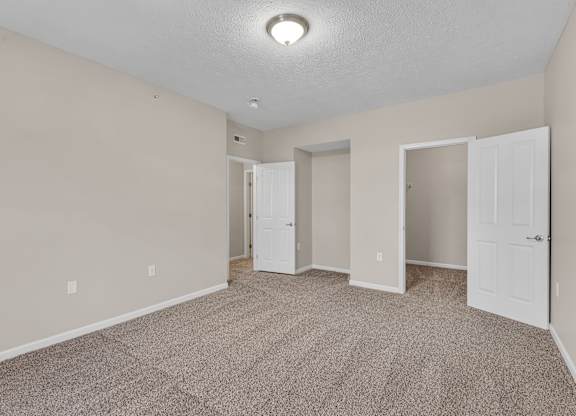 A room with carpeted floor and white doors.