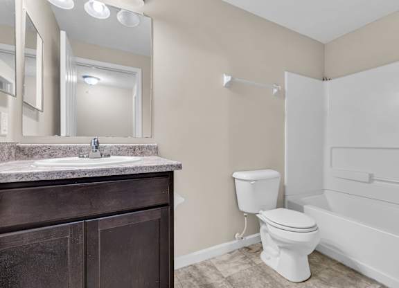 A bathroom with a toilet, sink, and bathtub.